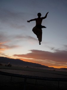 Photo takend of trampoline jump on beach at sunset.