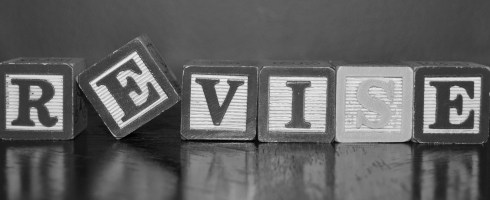 The word "revise" spelled out in wooden block letters.